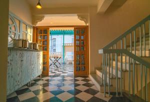 a hallway with a checkered floor in a house at Ostel By Orion Hotels -Udaipur in Udaipur