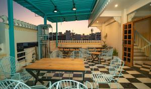 a patio with tables and chairs on a balcony at Ostel By Orion Hotels -Udaipur in Udaipur