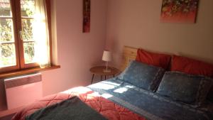 um quarto com uma cama e uma janela em Les hirondelles em Wangen