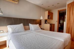 a bedroom with a large bed with white sheets at Elements Rooms & Apartments in Athens