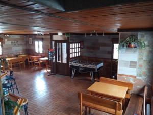 Habitación con mesa de ping pong, mesas y sillas en Hostal La Collada de Aralla, en Aralla de Luna