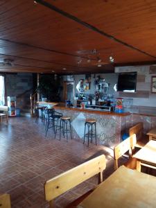 a restaurant with tables and chairs and a bar at Hostal La Collada de Aralla in Aralla de Luna