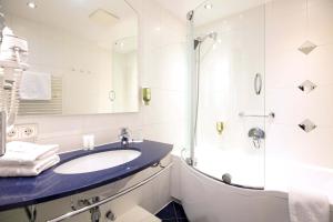 a bathroom with a sink and a shower at Hotel Mondschein in Innsbruck