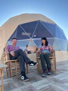 a man and a woman sitting in chairs in a tent at Moon Magic Valley in Wadi Rum