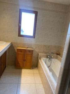 a bathroom with a tub and a sink and a window at Chez Cathy et Philippe in Vérargues