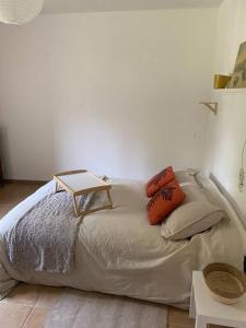 Una cama con almohadas y una mesa encima. en Chez Cathy et Philippe, en Vérargues