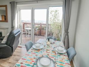 a dining room with a table and a couch at Bay View in Paignton