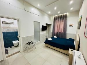 een slaapkamer met een blauw bed en een badkamer bij Room25mq in Cercola