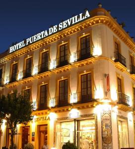 un edificio con un letrero que lee la puerta del hotel de Cyclolia en Basic Hotel Puerta de Sevilla en Sevilla