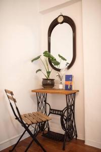 a table with a mirror and a chair and a table with a plant at Stay Hwangchon in Gyeongju