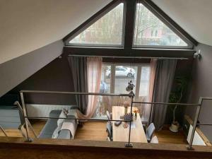 uma sala de estar com um sofá e uma grande janela em Wunderschöne Loft-Stadtwohnung em Wurtzburgo