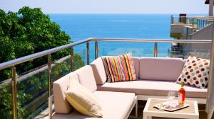 een balkon met een bank en een tafel bij Byala Cliff Sea View Penthouse in Byala