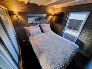 una camera con un letto su una parete in legno di Tiny House Flensburg Lee a Handewitt