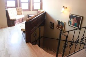 a hallway with a staircase with a chair and paintings at Hotel SultanHill in Istanbul