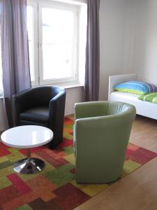 ein Zimmer mit zwei Stühlen und einem Tisch und einem Bett in der Unterkunft Bahnhofstr Apartment in Castrop-Rauxel