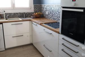 cocina con armarios blancos y encimera en Appartement de charme et familial à Caen, en Caen