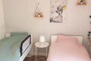 1 dormitorio con 2 camas individuales y mesa en Appartement de charme et familial à Caen, en Caen