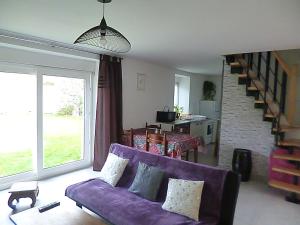 sala de estar con sofá púrpura y escalera en gite au calme centre finistère jardin clos, en Trégourez
