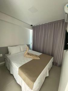 Un dormitorio con una cama con una toalla. en Edifício Promenade II Apt 1108 -Mandi Hospitalidade, en Maceió