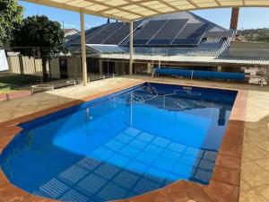 a large blue swimming pool in front of a building at Avon Homestay in Northam