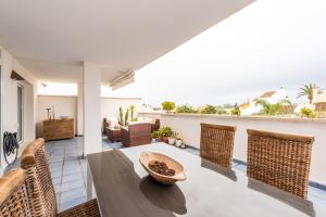 uma sala de estar com uma mesa e cadeiras de vime em Apartamento Altos de Banús III em Marbella