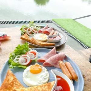 two plates of breakfast food on a table at Kram Farmstay in Nakhon Pathom