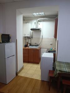 Il comprend une cuisine équipée d'un réfrigérateur blanc et d'une cuisinière. dans l'établissement Apartments Domovik on Valenberga 3, à Moukatcheve