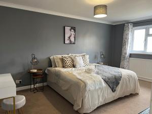 Un dormitorio con una cama grande y una ventana. en Charming 4-Bed House in Cheltenham Free Parking, en Cheltenham