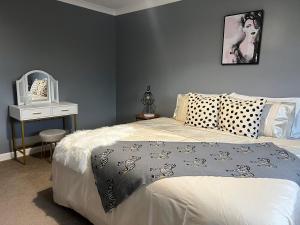 una camera con letto e tavolo con specchio di Charming 4-Bed House in Cheltenham Free Parking a Cheltenham
