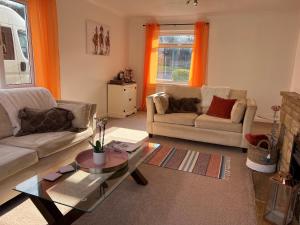 a living room with two couches and a coffee table at Charming 4-Bed House in Cheltenham Free Parking in Cheltenham