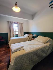 a bedroom with two beds and a window at Chalet de las Tejas in Rosario