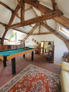 a room with a pool table in the attic at Gîte du Nouveau Monde in Langoëlan