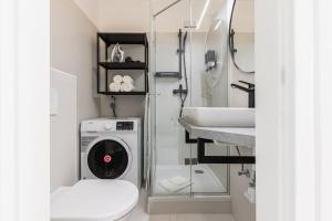 y baño con lavadora y lavamanos. en Bright stylish apartment with a balcony in a top location en Viena