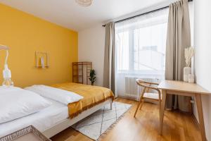 1 dormitorio con cama, escritorio y ventana en Bright stylish apartment with a balcony in a top location en Viena