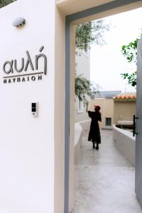 a woman is standing outside of a building at αυλή Ναύπλιον in Nafplio