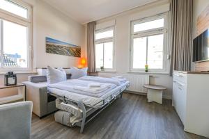 een hotelkamer met een bed en twee ramen bij Haus Inselanker Kajüte 05 in Norderney