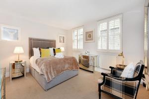 a bedroom with a bed and two tables and two windows at London Choice Apartments - South Kensington - Mews House II in London