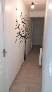 a hallway with a tree stenciled on a wall at Le Watt'else in Watten