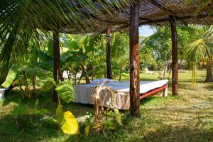 a bed under a pergola in the grass at Mama Africa Art Residence & Art Center Gambia in Tanji