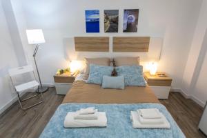 1 dormitorio con 1 cama grande y 2 toallas. en Apartamento renovado y confortable en el centro de Granada, en Granada