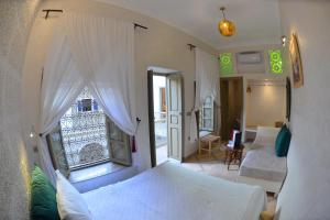 Riad Marana Hotel & Spa في مراكش: غرفة نوم بسريرين ونافذة كبيرة
