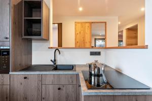 a kitchen with wooden cabinets and a sink at Villa Lara Lärche in Castelrotto