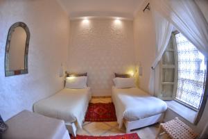 A bed or beds in a room at Riad Marana Hotel & Spa