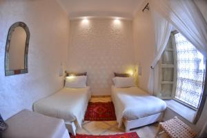 Cette petite chambre comprend 2 lits et une fenêtre. dans l'établissement Riad Marana Hotel & Spa, à Marrakech