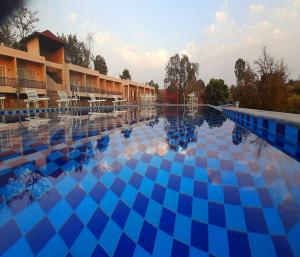 a swimming pool at a resort with blue tiles at Kumbhal Exotica Resort Kumbhalgarh in Kumbhalgarh