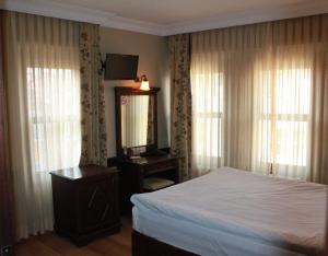 a bedroom with a bed and a dresser and a mirror at Hotel SultanHill in Istanbul