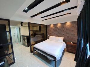 um quarto com uma cama num quarto em Burgundy McKinley Place Service Apartment em Manila