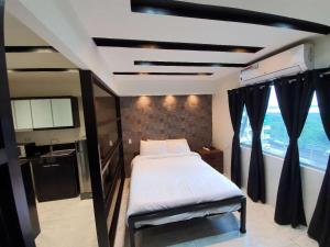 a bedroom with a large bed and a window at Burgundy McKinley Place Service Apartment in Manila