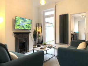 a living room with two blue chairs and a fireplace at The Avenue Townhouse in Leicester