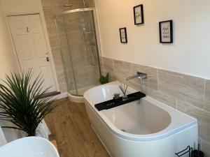 a white bath tub in a bathroom with a shower at The Avenue Townhouse in Leicester